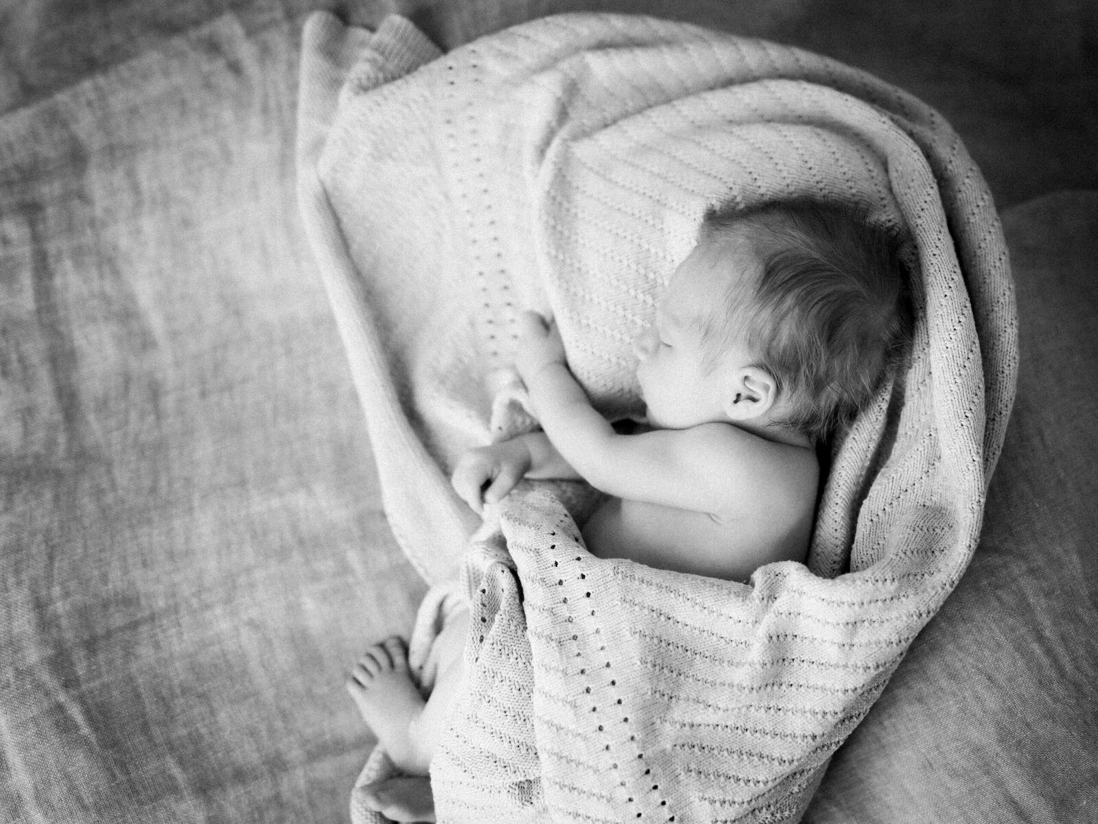 neugeborenes baby in decke gehüllt schwarz weiss