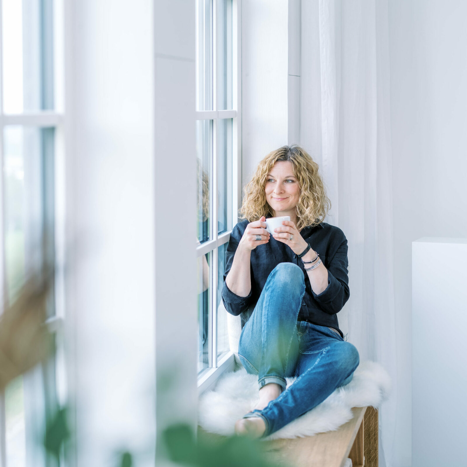 Babyfotografin Nicole Mosbacher sitz am Fenster